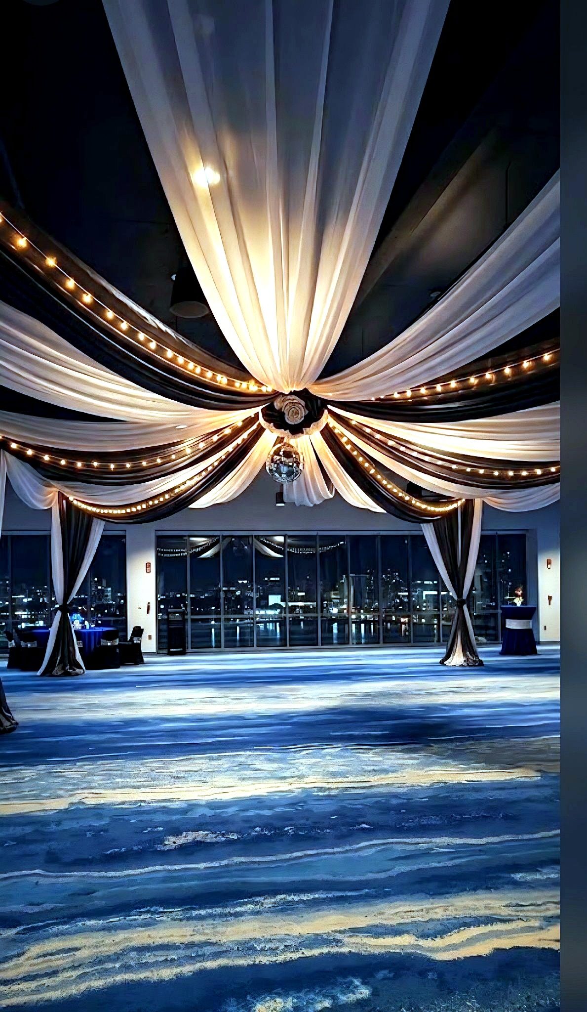 Ceiling drapery — starburst ceiling drape glowing over an empty dance floor at night, by Altitude Event Design and Decor, Tampa Bay